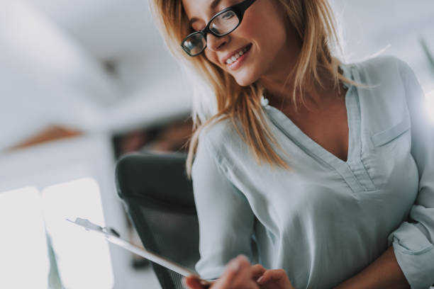istock Close up of pretty woman smiling while looking at notes 1148917456