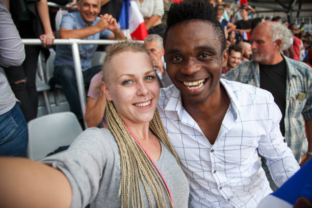 istock Interracial couple at footbal match making selfie 1148919590