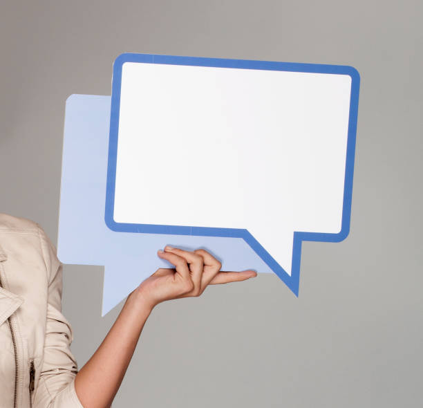 istock woman holding big blue speaking balloon on grey background 1148921392