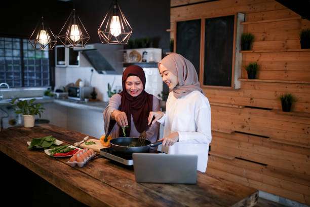 istock Daughter help mother preparing food with laptop 1148923697