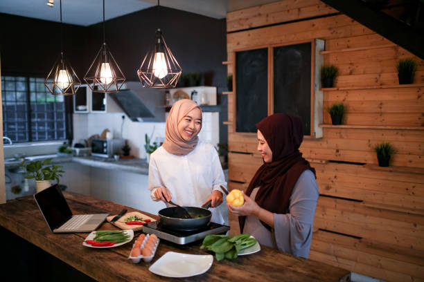 istock Daughter help mother preparing food with laptop 1148923712