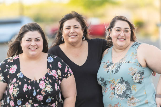 Hispanic senior woman posing with her mid adult daughters Hispanic senior woman posing with her mid adult daughters looking at the camera smiling lgbtqcollection stock pictures, royalty-free photos & images