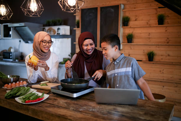 Sibling help mother cooking with laptop