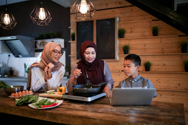 istock Sibling help mother cooking with laptop 1148937530
