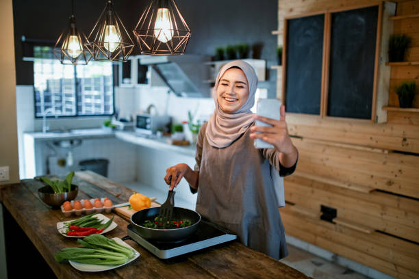 One women looking at phone while cooking
