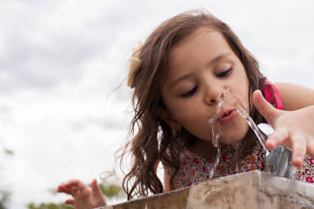istock Latin girl playing with a jet of water while they drinking. 1148939253