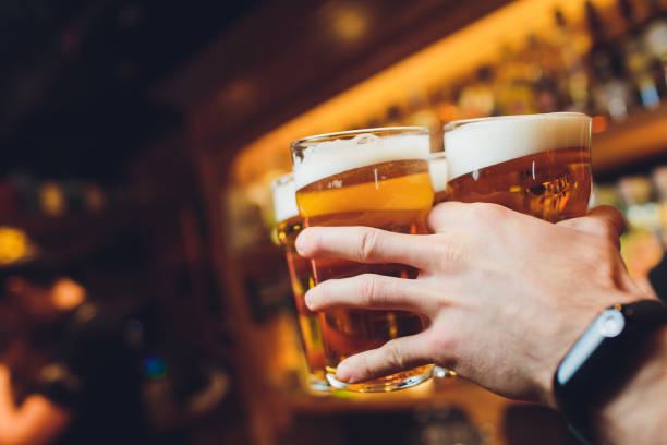 istock Barman hands pouring a lager beer in a glass. 1148939353