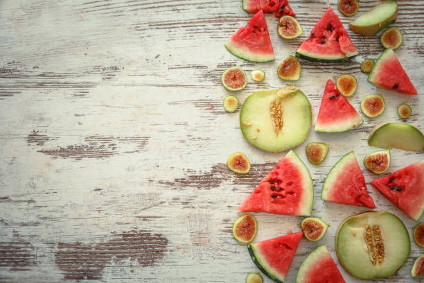 Slices of watermelon, melon and fig on wooden background