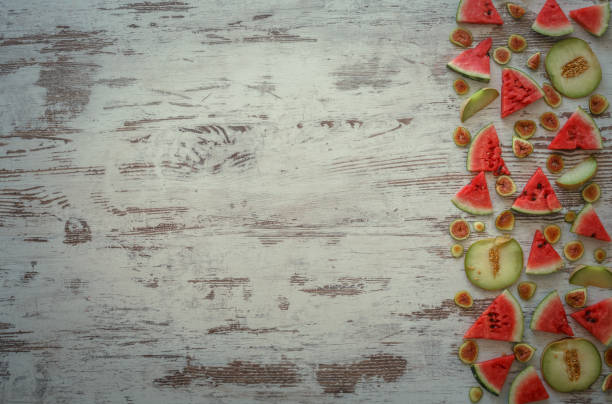 Sliced watermelons, melons and figs arranged on wooden background