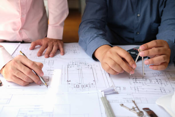 istock architect engineer team working on house blueprint of real estate project at workplace. construction & building concept 1148939831