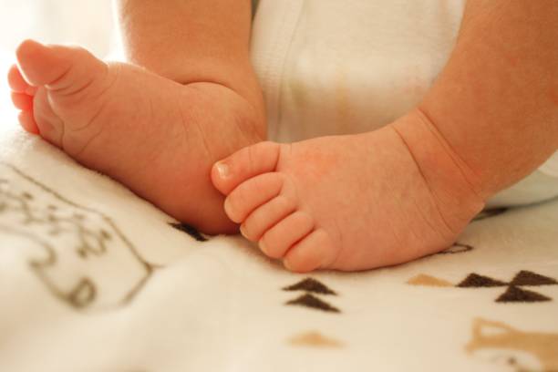 istock Newborn baby feet resting on blanketed changing table 1148941323