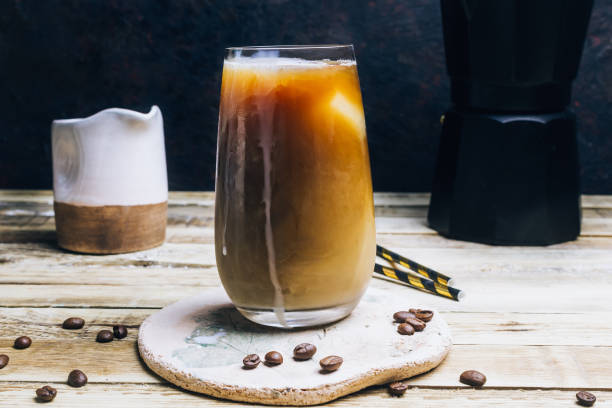 istock Ice coffee in a tall glass on a old rustic wooden table. Cold summer drink 1148943606