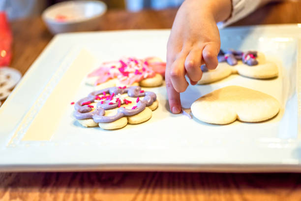 istock Closeup of child decorating cookies with 1148943742