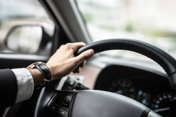 istock Cropped hands of man driving car 1148943748