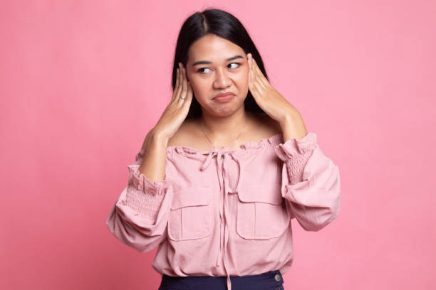 istock Young Asian woman block both ears with fingers. 1148949372