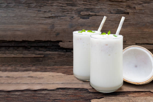 batidos de coco licuados de jugo de fruta blanca mezcla de bebidas saludables de alta proteína el sabor delicioso en copa de vidrio episodio mañana en un fondo de madera. - blender food processor white isolated fotografías e imágenes de stock