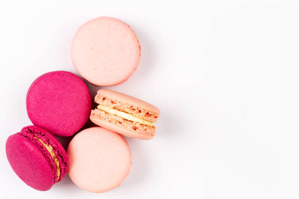 French pink and magenta macarons or macaroons, top view on a white background with copyspace