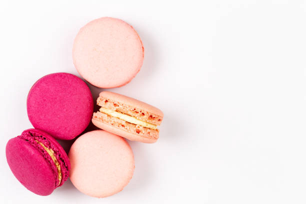French pink and magenta macarons or macaroons, top view on a white background with copyspace stock photo