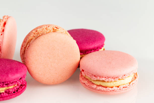istock French pink macarons or macaroons, closeup, side top view on a white background. 1148962161