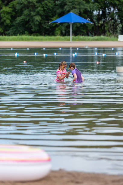 istock Two Girls Playing In Water At Beach on Summer Day 1148963671