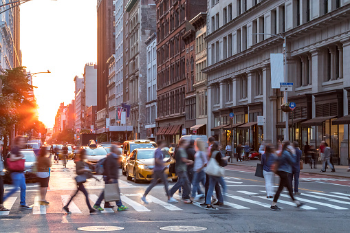 Crowds of people in motion across the busy intersection of 23rd Street and 5th Avenue in Midtown Manhattan, New York City NYC