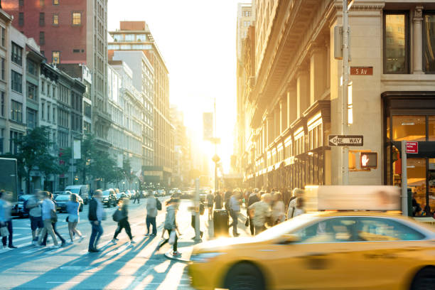 taxi amarillo de la ciudad de nueva york velocidades más allá de las multitudes de personas una intersección en manhattan - centro de manhattan fotografías e imágenes de stock
