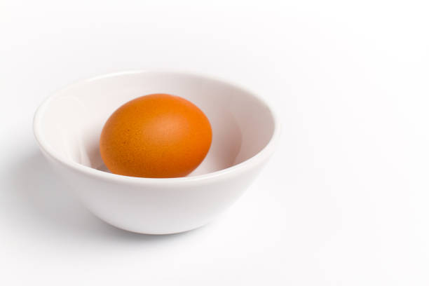 istock Egg in a bowl isolated on white background 1148973168