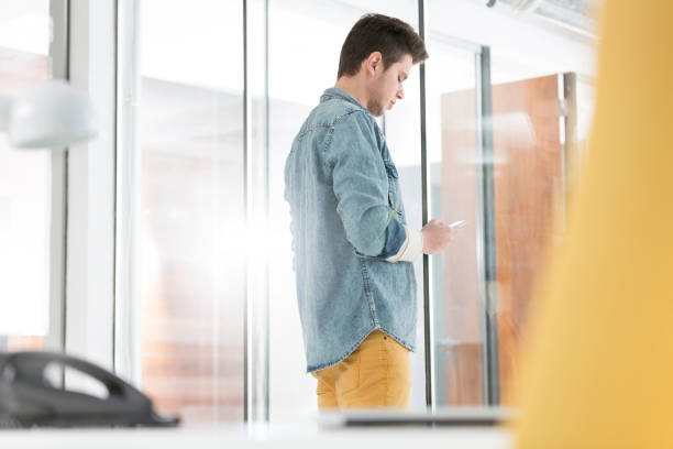 istock Side view of businessman messaging on smartphone in office 1148978189