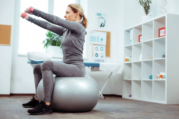 istock Nice good looking woman sitting on the med ball 1148979059