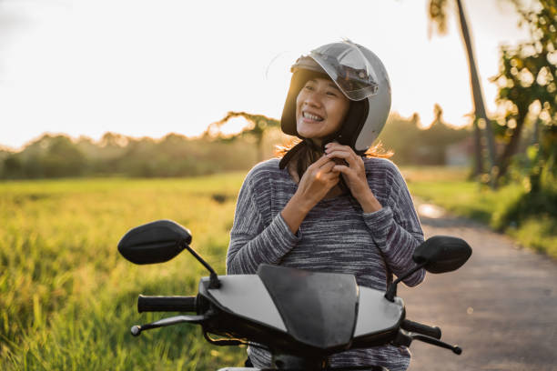 istock woman wearing and fasten her helmet while riding 1148979370