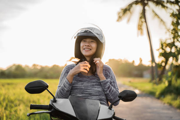 istock woman wearing and fasten her helmet while riding 1148980015