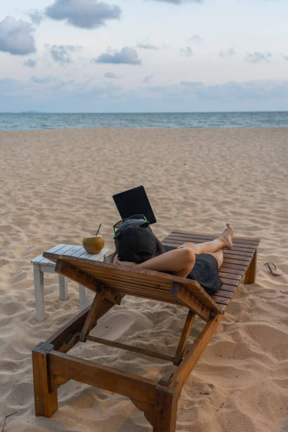 istock Young tourist use tablet and drink coconut on the beach 1148980306