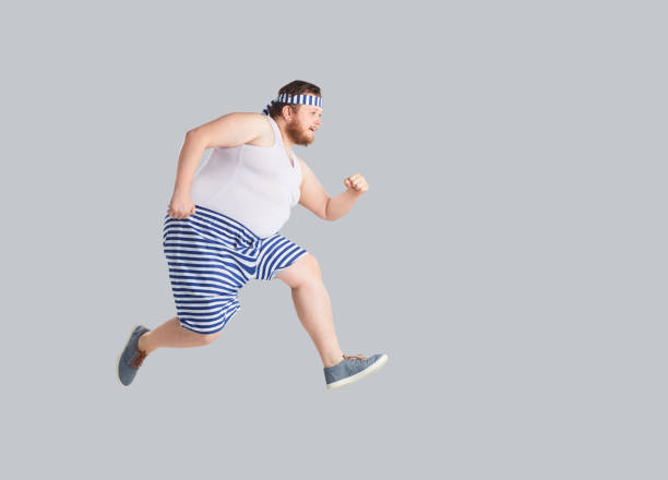 Funny Man In Striped Shorts Runs On A Gray Background Stock Photo -  Download Image Now - iStock