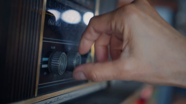 Close-up of hands using analog vintage radio