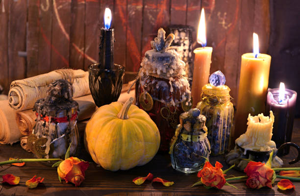 istock Old paper scrolls, pumpkin, candles and magic bottles on witch table. 1148981876
