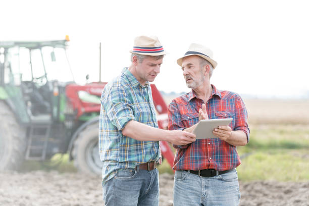 istock Farmers with digital tablet discussing at farm 1148982776