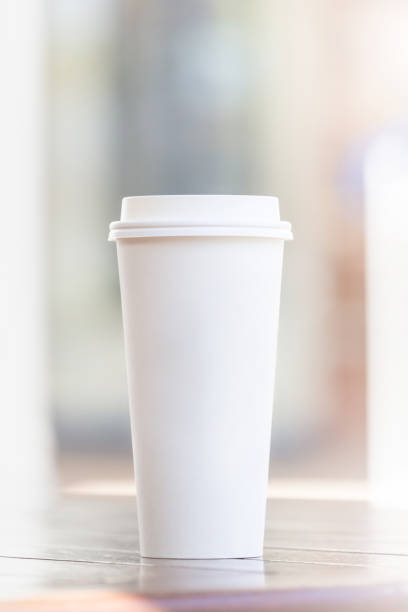 istock Disposable coffee cup and smartphone on wooden table at cafe terrace blurred background 1148984121