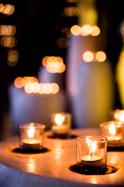 istock Flame of many candles burning on blurred lights background. 1148984217