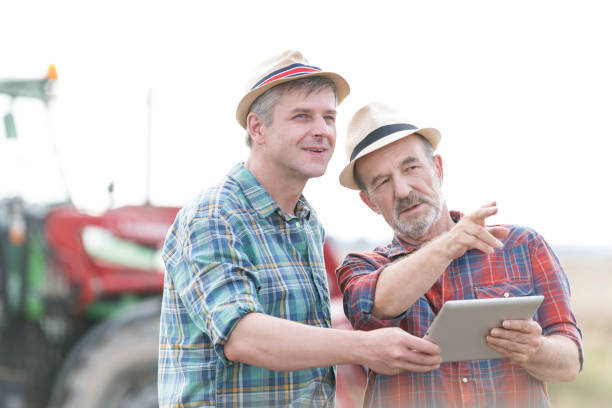 istock Confident farmers with digital tablet discussing at farm 1148984371