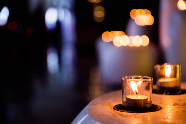 istock Flame of many candles burning on blurred lights background. 1148986973