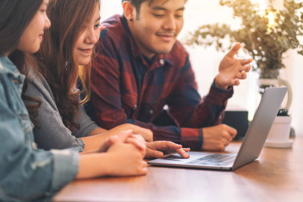 istock Three young asian people using and looking at the same laptop computer during a meeting 1148989568