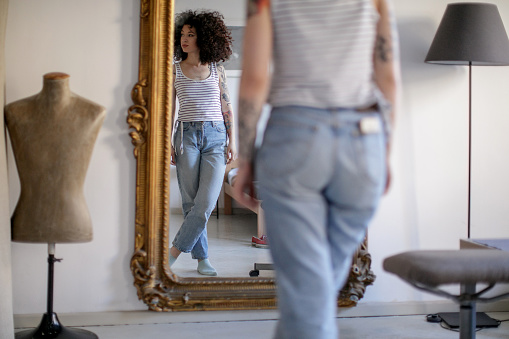 Reflejo de joven tatuada mujer en el espejo photo