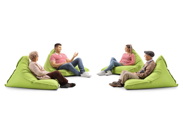 istock Young and senior people sitting on bean bag chairs and talking 1148990484