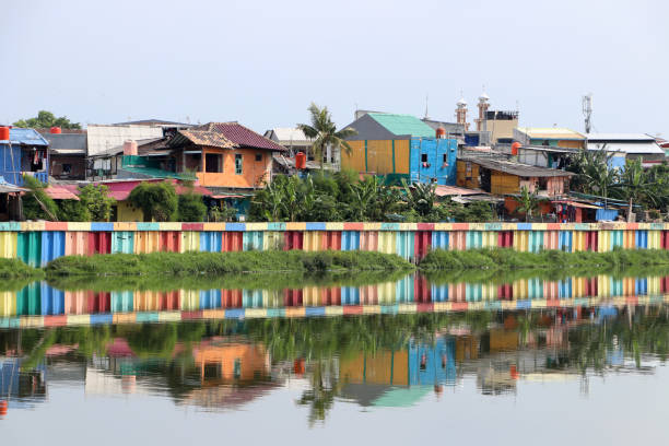 Rainbow village in Indonesia, colorful houses and colorful dam along the canal of slum. Rainbow village in Indonesia, colorful houses and colorful dam along the canal of slum, all that reflected in the water. jakarta slums stock pictures, royalty-free photos & images
