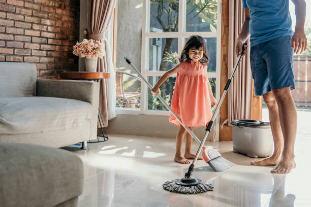 istock father and daughter clean up the house 1148993337