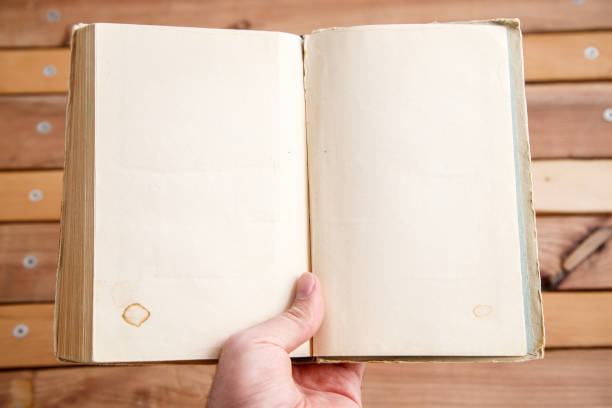 istock sheets of book with empty space on wooden background 1148994463