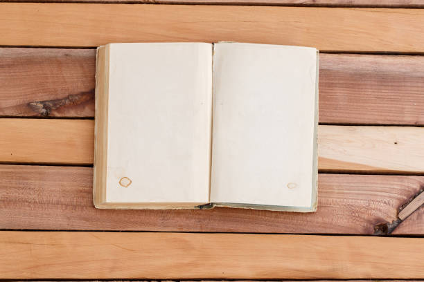 istock sheets of book with empty space on wooden background 1148994481