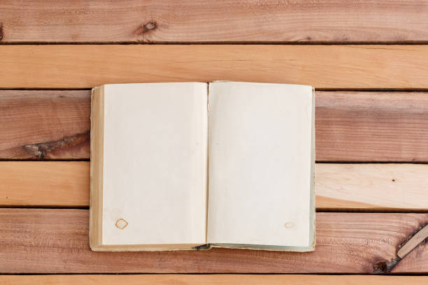 istock sheets of book with empty space on wooden background 1148994485