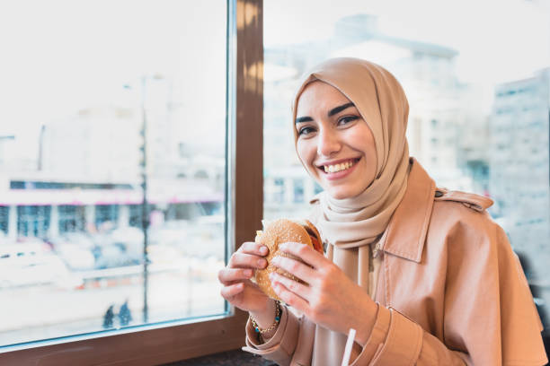 istock Modern Muslim woman eats a big hamburger 1148994745