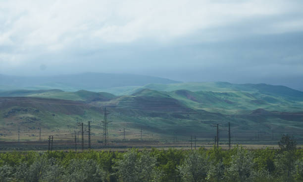 istock Windmills and high-voltage electrical towers along the road 1148996377